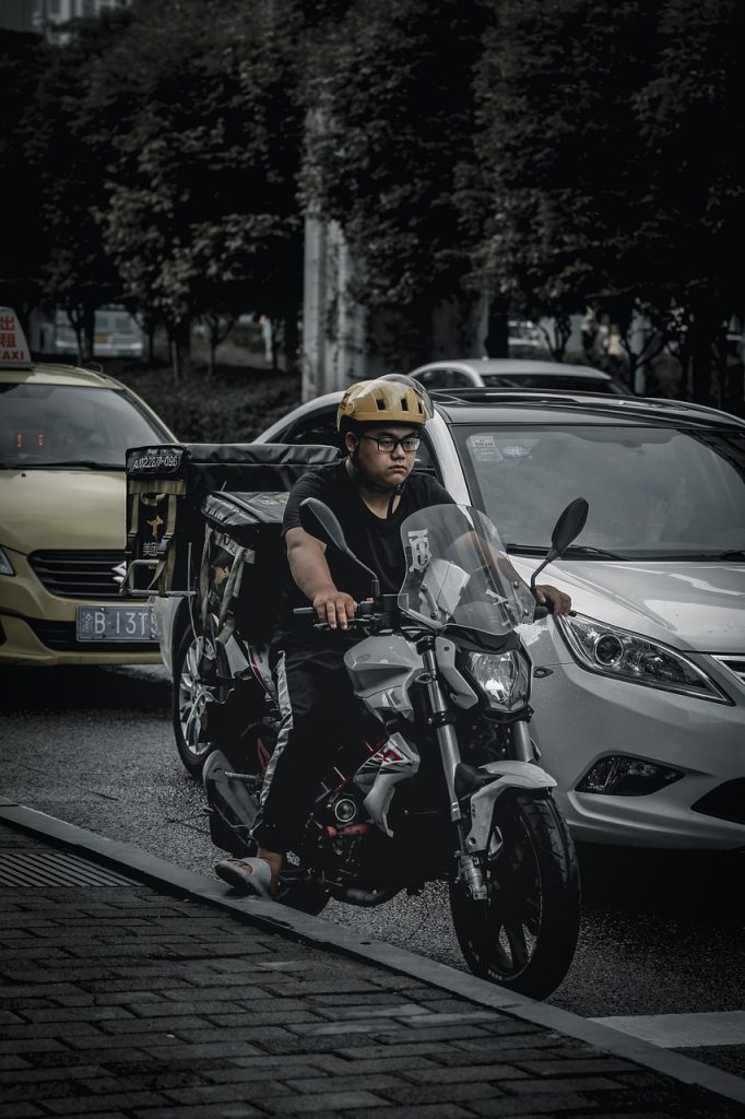 delivery rider sweating in summer heat checking phone