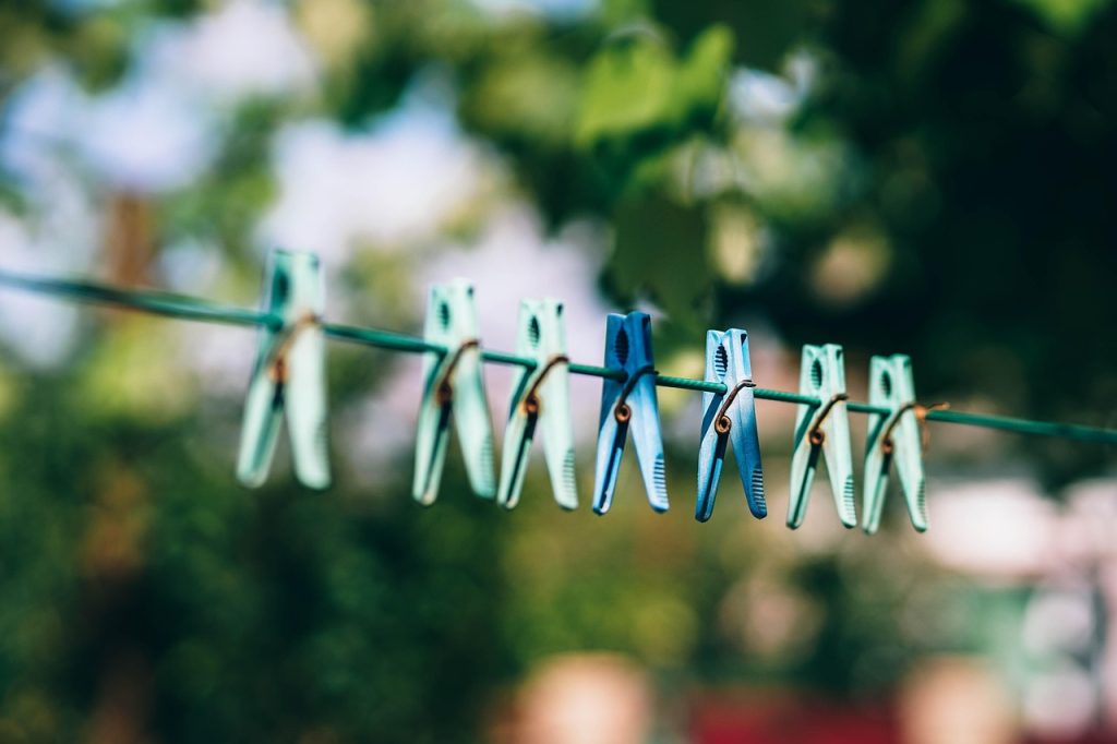 white shirts drying in direct sunlight on outdoor clothesline