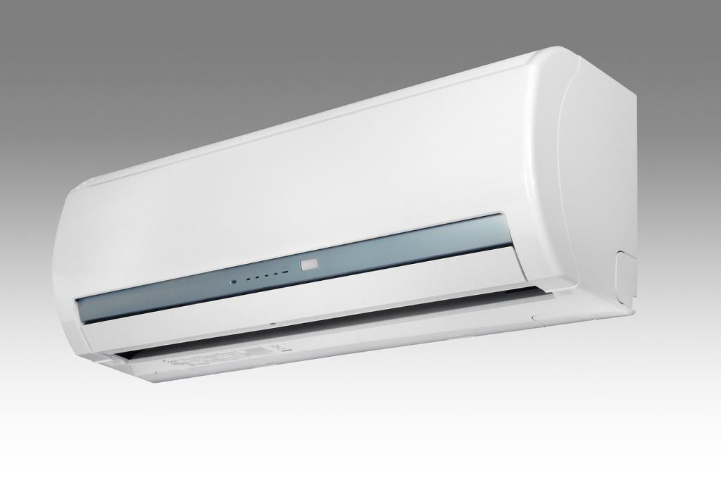 person checking air conditioner filter for damage in well-lit apartment