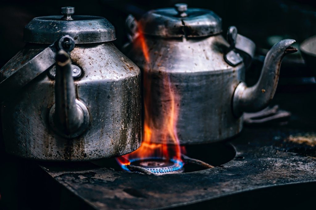 gas stove burner caps soaking in boiling water with dish soap