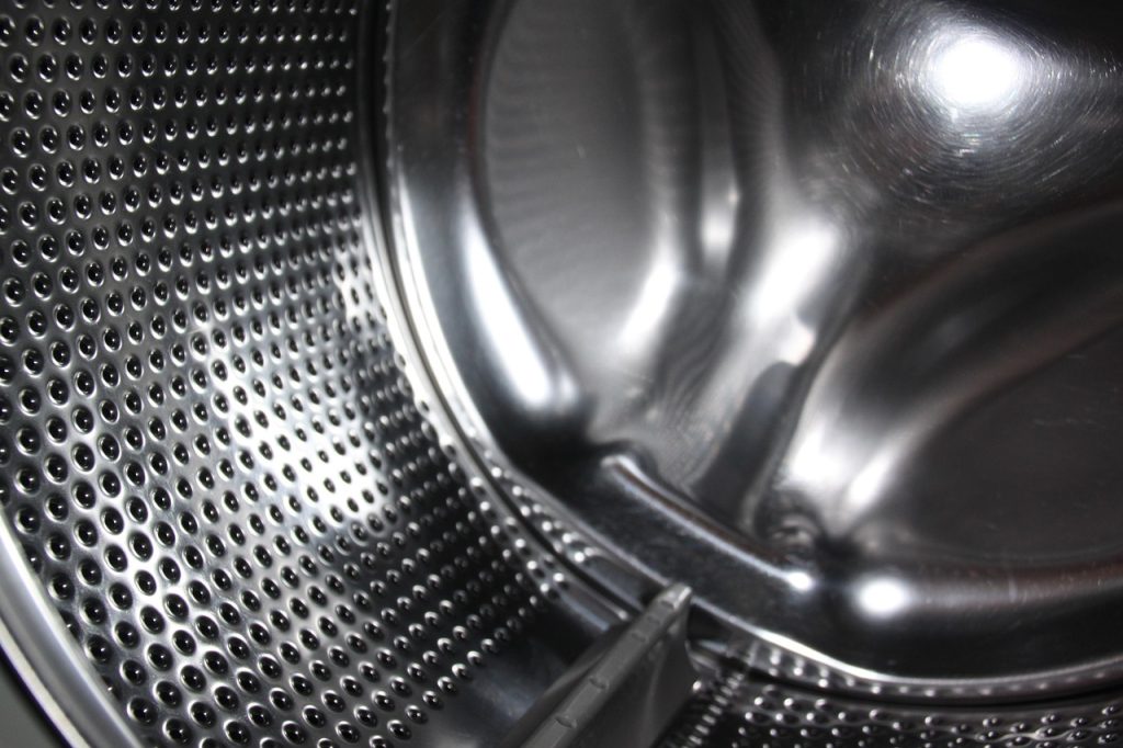 drum washing machine rubber door seal being cleaned with toothbrush