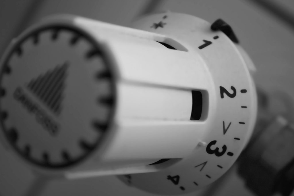 hand adjusting refrigerator temperature dial