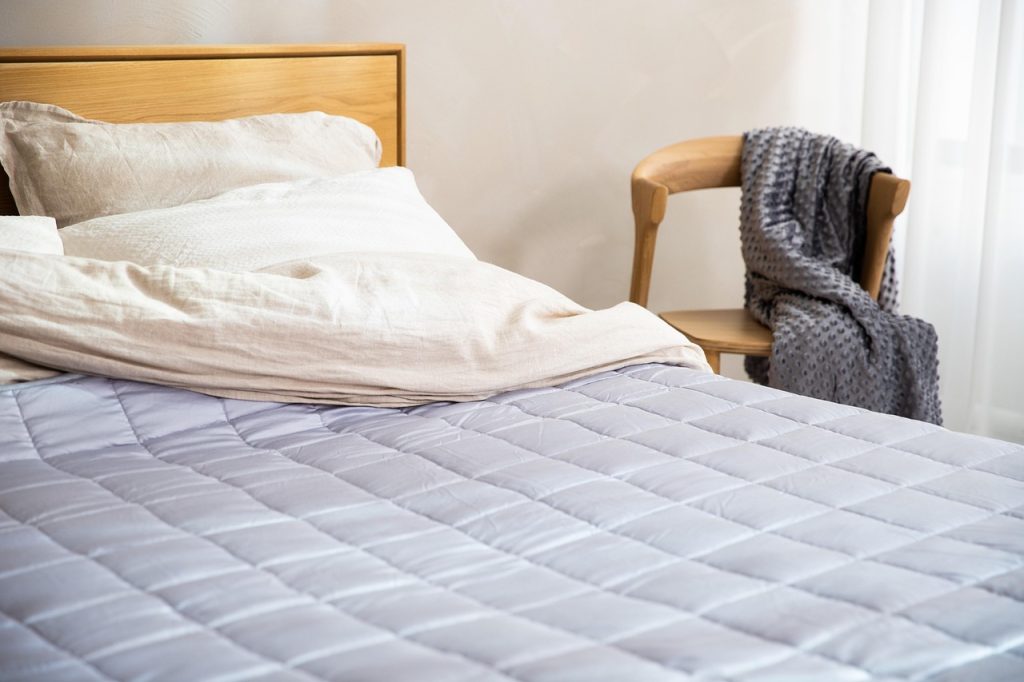 clean white mattress protector pad on summer bed