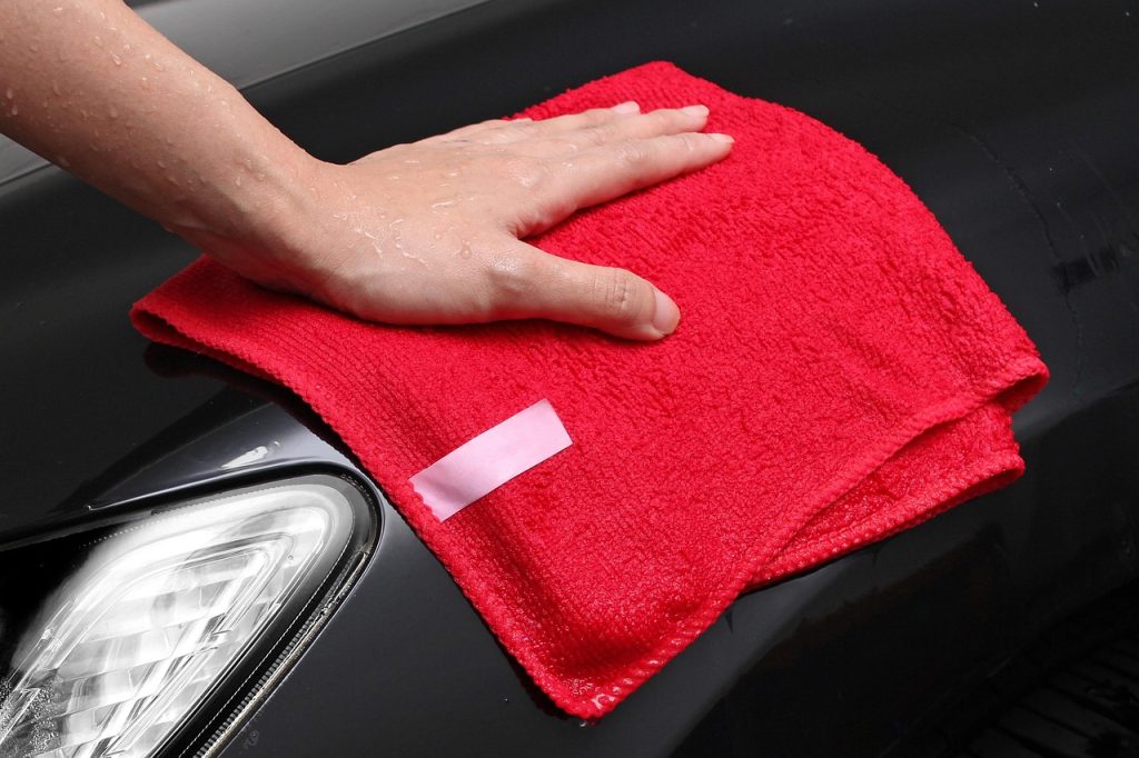 microfiber wet cloth wiping wooden furniture surface