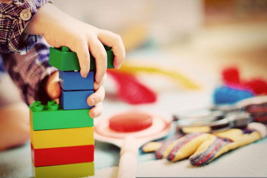 child playing focused with wooden building blocks alone