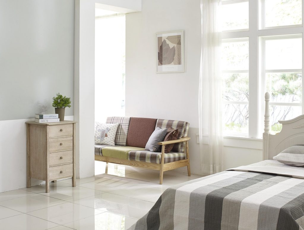 cluttered items beside a fabric sofa in a living room