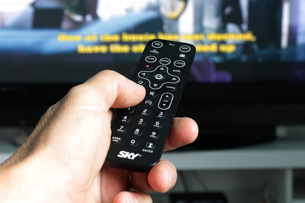 small woven basket on TV stand holding remote controls