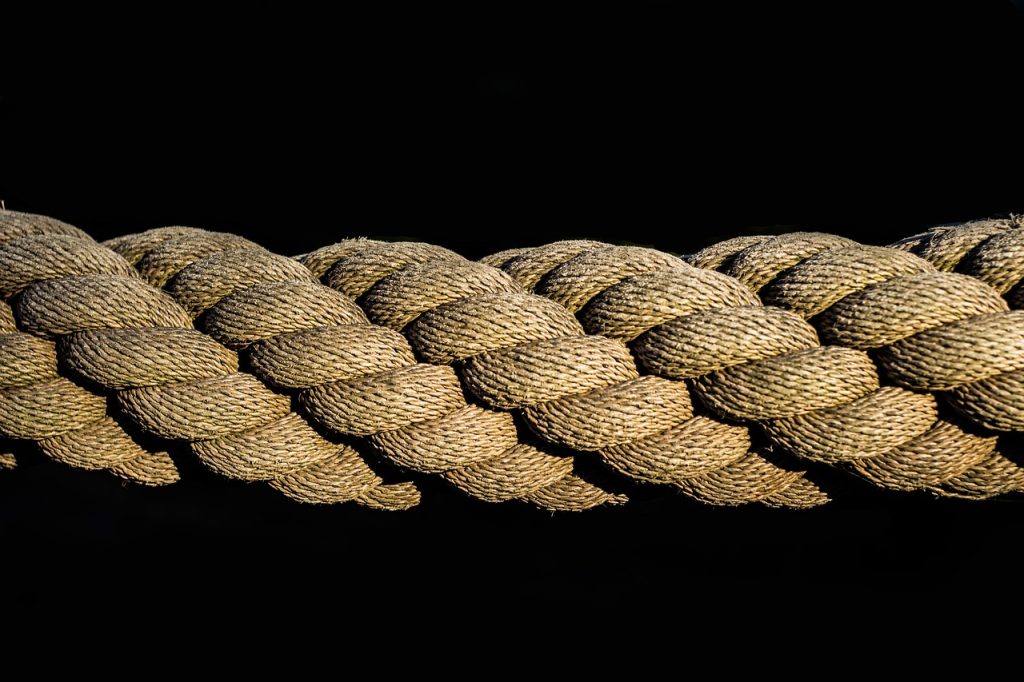 rolling thick blanket tightly by hand on wooden floor