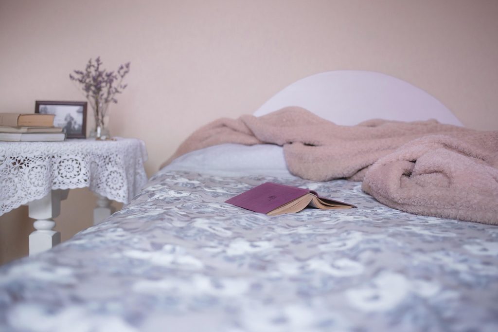 seasonal bedding folded neatly on bed in bright room