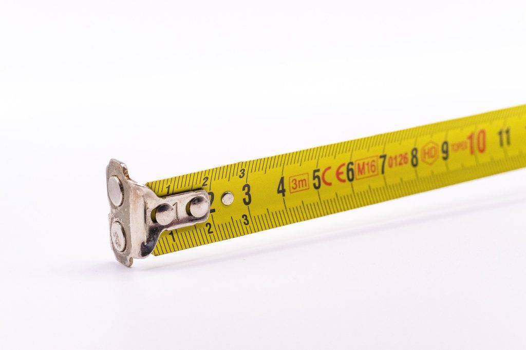measuring tape placed in narrow entryway to measure width before buying