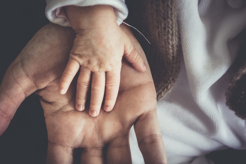 adult child helping elderly parent sort through items at home, gentle and warm atmosphere