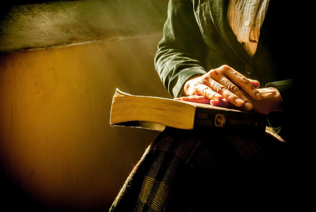 person sitting peacefully in a tidy room, warm morning sunlight, journaling or reading