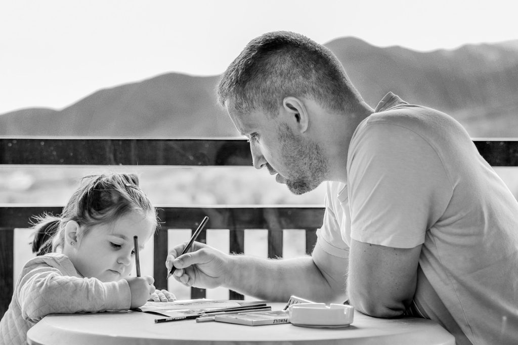 parent and child sitting together selecting drawings to keep