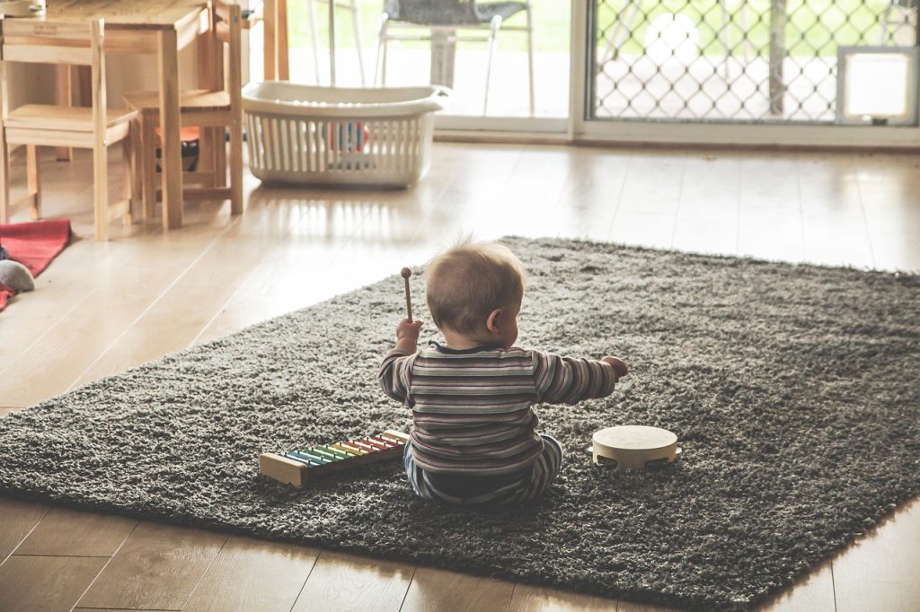 child playing with toys in a simply arranged kids room during moving day